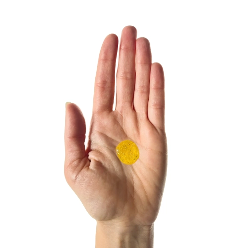 Kropla żółtego olejku Absolut Repair Molecular na otwartej dłoni.