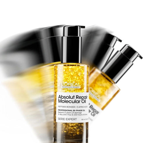 Zbliżenie butelki olejku Absolut Repair Molecular z widocznymi złotymi pęcherzykami w płynie.