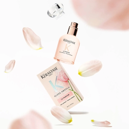 Kérastase Gloss Absolu Le Parfum – flakon i pudełko perfum wśród płatków kwiatów