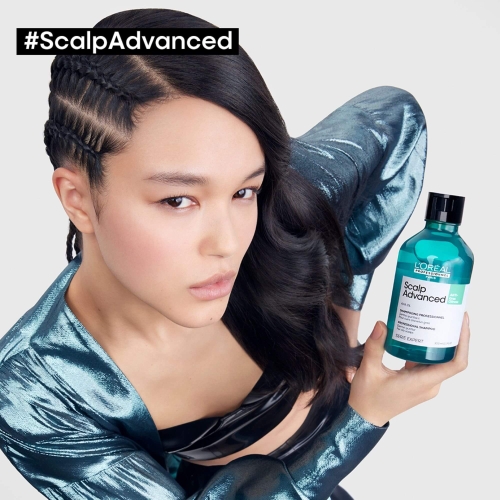 Modelka z długimi, gładkimi włosami trzymająca butelkę szamponu L’Oréal Scalp Advanced Anti-Oiliness.